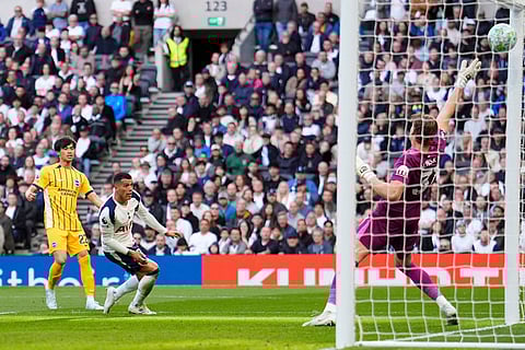 Brighton and Hove Albion's Kaoru Mitoma,left, scores their first goal in an English Premier League soccer match between Tottenham Hotspur and Brighton and Hove Albion in London.