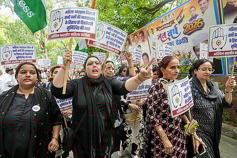 Congress workers hold placards during a protest march towards the BJP headquarters over the Constitution (131st Amendment) Bill on women's reservation, in New Delhi.