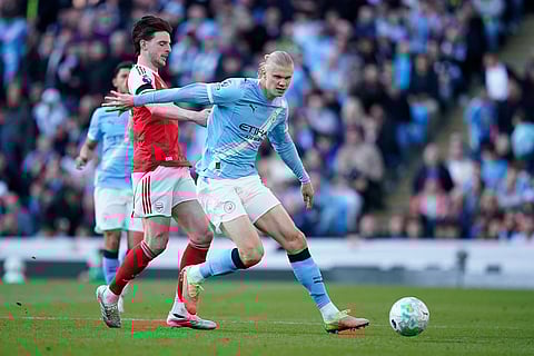 Manchester City's Erling Haaland challenges for the ball with Arsenal's Declan Rice during the English Premier League soccer match between Manchester City and and Arsenal, in Manchester, England.