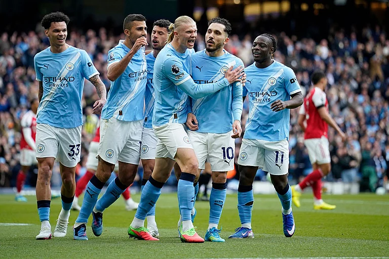 Manchester City's Rayan Cherki celebrates with his teammates after scoring his side's first goal during the English Premier League soccer match between Manchester City and and Arsenal, in Manchester, England. - | Photo: AP/Dave Thompson