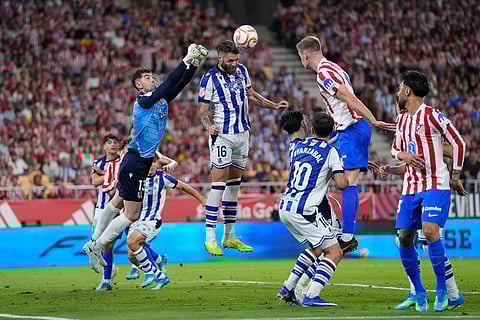 Atletico Madrid's Alexander Sorloth, second from right, challenges for the ball with Real Sociedad's Duje Caleta-Car, centre, and goalkeeper Unai Marrero, top left, during the Copa del Rey final soccer match between Atletico Madrid and Real Sociedad in Seville, Spain.