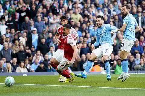 Manchester City's Rayan Cherki scores his side's first goal during the English Premier League soccer match between Manchester City and and Arsenal, in Manchester, England.