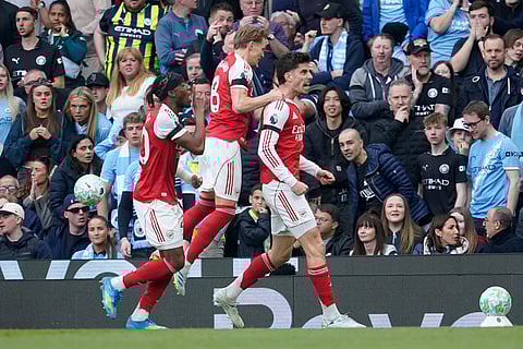 Arsenal's Kai Havertz celebrates with his teammates after scoring his side's first goal during the English Premier League soccer match between Manchester City and and Arsenal, in Manchester, England.