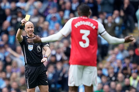 Arsenal's Cristhian Mosquera receives a yellow card from referee Anthony Taylor during the English Premier League soccer match between Manchester City and and Arsenal, in Manchester, England.