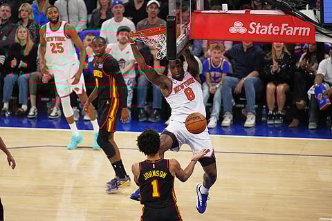 New York Knicks' Og Anunoby (8) dunks the ball in front of Atlanta Hawks' Jalen Johnson (1) during the first half in Game 1 of a first-round NBA playoffs basketball series in New York.