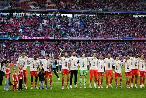 Bayern players celebrate after their team clinched the German league title after a Bundesliga soccer match between Bayern and Stuttgart in Munich, Germany.