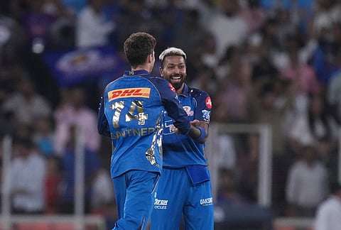 Mumbai Indians' captain Hardik Pandya , right, and Mumbai Indian's Mitchell Santner, left, celebrates the wicket of Gujarat Titans' Washington Sundar during the Indian Premier League cricket match between Gujarat Titans and Mumbai Indians in Ahmedabad.