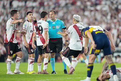 Players of River Plate completing to Referee Dario Herrera during an Argentine soccer league match against Boca Juniors in Buenos Aires, Argentina.