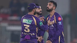 | Photo: AP/Ajit Solanki : Kolkata Knight Riders' Varun Chakaravarthy, right, celebrates with teammates the wicket of Gujarat Titans' Jos Buttler during the Indian Premier League cricket match between Gujarat Titans and Kolkata Knight Riders in Ahmedabad.