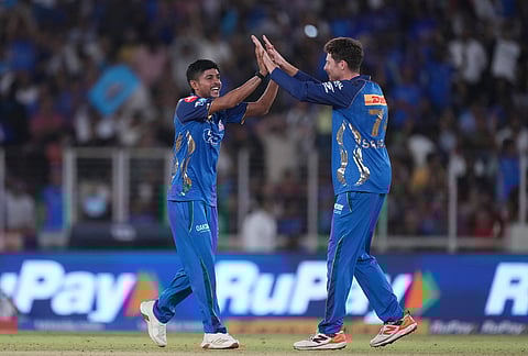 Mumbai Indian's Mitchell Santner, right, and Mumbai Indians' Ashwani Kumar celebrates the wicket of Gujarat Titans' Rashid Khan during the Indian Premier League cricket match between Gujarat Titans and Mumbai Indians in Ahmedabad.