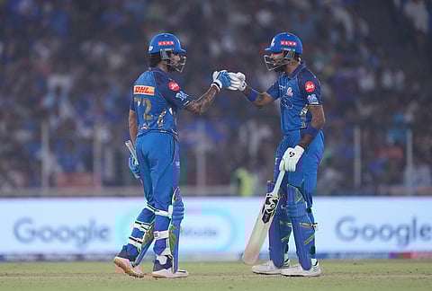Mumbai Indians' Tilak Verma, left, and his batting partner Hardik Pandya celebrate scoring runs during the Indian Premier League cricket match between Gujarat Titans and Mumbai Indians in Ahmedabad.