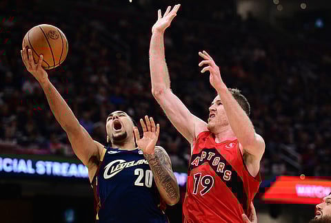 Cleveland Cavaliers guard Jaylon Tyson, left, goes to the basket against Toronto Raptors center Jakob Poeltl during the second half in Game 1 of a first-round NBA playoffs basketball series, in Cleveland. 