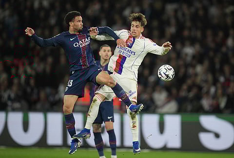 Lyon's Afonso Moreira, right, and PSG's Warren Zaire-Emery challenge for the ball during the French League One soccer match between Paris Saint-Germain and Olympique Lyon in Paris, France.