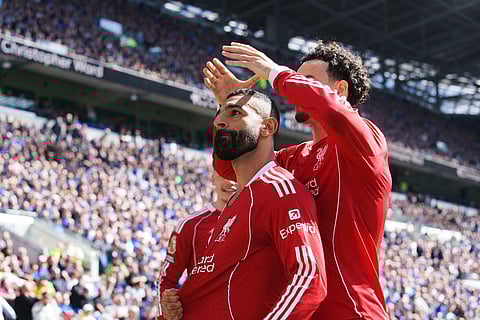 Liverpool's Mohamed Salah, left, is congratulated after scoring his side's opening goal during the English Premier League soccer match between Everton and Liverpool in Liverpool, England.