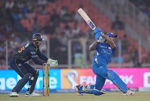 Mumbai Indians' Tilak Verma hits a six during the Indian Premier League cricket match between Gujarat Titans and Mumbai Indians in Ahmedabad.