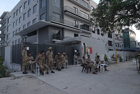 Police persons stand guard outside a factory at Noida Sector 63 due to recent protest by labours
