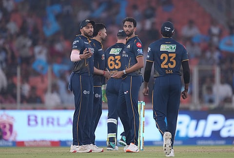 Gujarat Titans' Prasidh Krishna, centre, celebrates with teammates the wicket of Mumbai Indians' Naman Dhir during the Indian Premier League cricket match between Gujarat Titans and Mumbai Indians in Ahmedabad.
