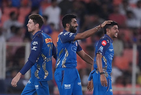 Mumbai Indians' Ashwani Kumar, right, celebrates the wicket of Gujarat Titans' Rahul Tewatia during the Indian Premier League cricket match between Gujarat Titans and Mumbai Indians in Ahmedabad.