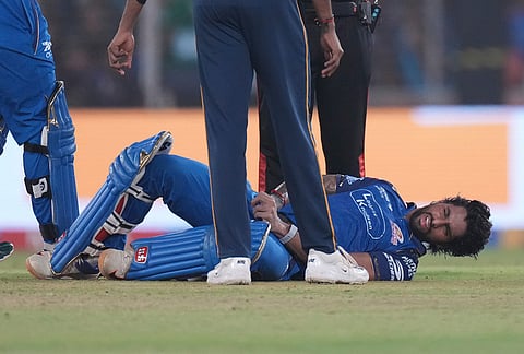 Mumbai Indians' Tilak Verma reacts after being hit by a ball during the Indian Premier League cricket match between Gujarat Titans and Mumbai Indians in Ahmedabad.