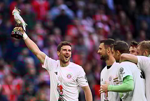 Bayern's Leon Goretzka, holds a cockatoo trophy as he celebrates after winning the German championship at the end of the Bundesliga soccer match between Bayern and Stuttgart in Munich, Germany.