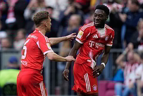 Bayern's Joshua Kimmich, left, and Alphonso Davies celebrate after scoring during a Bundesliga soccer match between Bayern and Stuttgart in Munich, German.