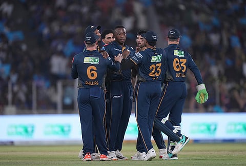 Gujarat Titans' Kagiso Rabada, centre, celebrates with teammates the wicket of Mumbai Indians' Suryakumar Yadav during the Indian Premier League cricket match between Gujarat Titans and Mumbai Indians in Ahmedabad.