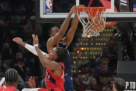 Cleveland Cavaliers center Evan Mobley, rear, dunks behind Toronto Raptors forward Collin Murray-Boyles, front, in the first half in Game 2 of a first-round NBA basketball playoffs series in Cleveland.