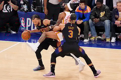 New York Knicks guard Jalen Brunson, left, drives past Atlanta Hawks guard Nickeil Alexander-Walker, center, during the first half in Game 2 of a first-round NBA playoffs basketball series in New York.