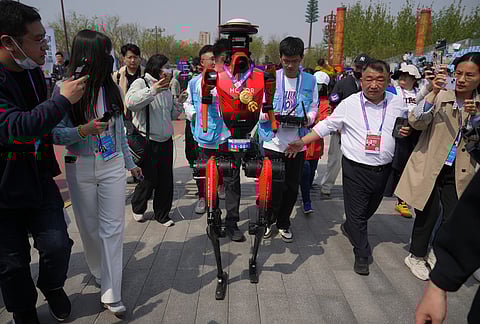 The winner of the humanoid robot half-marathon from Honor is chased by journalists after a press conference at the Beijing E-Town Half Marathon and Humanoid Robot Half-Marathon on the outskirts of Beijing.