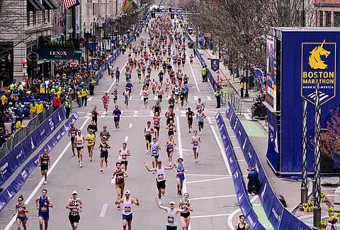 Runners stride down Boylston Street while approaching the finish line of the Boston Marathon, in Boston.