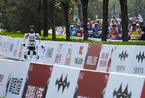 A robot competes along side with human in the Beijing E-Town Half Marathon and Humanoid Robot Half-Marathon held in the outskirts of Beijing.