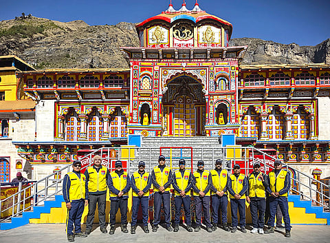 State Disaster Response Force (SDRF) officials pose for a group picture amid preparations ahead of the door-opening ceremony of Badrinath Dham, in Chamoli.