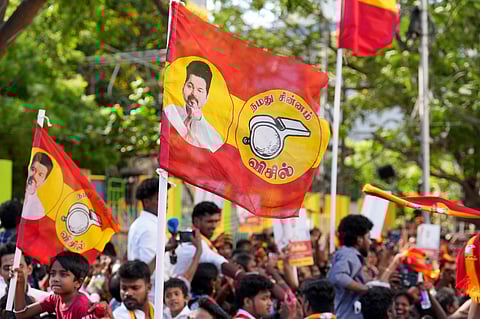 Tamilaga Vettri Kazhagam (TVK) supporters wave party flags during a roadshow  ahead of the Tamil Nadu Assembly elections.