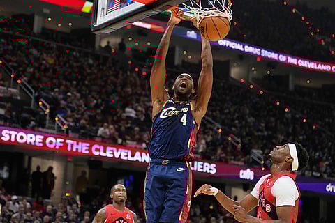 Cleveland Cavaliers center Evan Mobley (4) dunks next to Toronto Raptors guard Ja'kobe Walter, right, in the second half in Game 2 of a first-round NBA basketball playoffs series in Cleveland.
