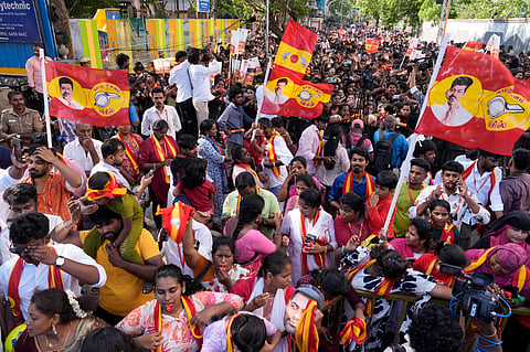 Tamilaga Vettri Kazhagam (TVK) supporters wave party flags during a roadshow led by party chief and candidate from the Tiruchirappalli East constituency, Vijay, ahead of the Tamil Nadu Assembly elections.