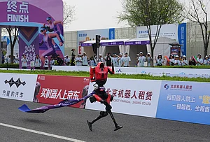 | Photo: AP/Andy Wong : A robot tagged along a ribbon as it crossing the finish line in the Beijing E-Town Half Marathon and Humanoid Robot Half-Marathon on the outskirts of Beijing.