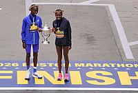 | Photo: AP/Charles Krupa : Boston Marathon winner John Korir of Kenya, left, holds the trophy with women's division winner Sharon Lokedi, also of Kenya, at the finish line of the Boston Marathon, in Boston. 