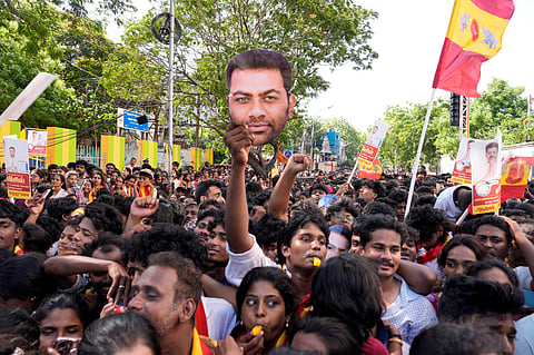 TVK supporters blow a whistle, party's symbol, during a roadshow ahead of the Tamil Nadu Assembly elections.