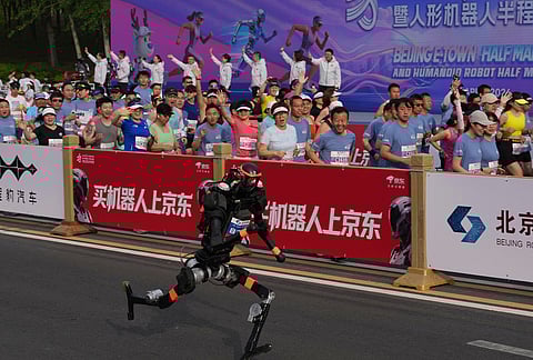 A robot starts off next to human marathon runners for the Beijing E-Town Half Marathon and Humanoid Half Marathon held on the outskirts of Beijing.
