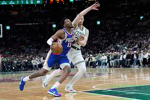 Philadelphia 76ers forward Justin Edwards (11) drives against Boston Celtics forward Sam Hauser, right, during the second half in Game 1 of a first-round NBA playoffs basketball game in Boston.
