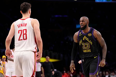 Los Angeles Lakers forward LeBron James, right, celebrates after scoring as Houston Rockets center Alperen Sengun watches during the first half in Game 2 of a first-round NBA playoffs basketball series in Los Angeles.