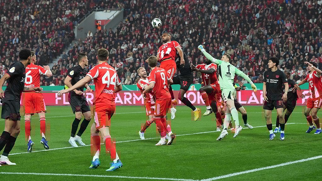 Bayern's Jonathan Tah and Leverkusen's Edmond Tapsoba goes for header during the German Soccer Cup semifinal match between Bayer Leverkusen and Bayern Munich in Leverkusen, Germany, Wednesday, April 22, 2026.  - AP Photo/Martin Meissner