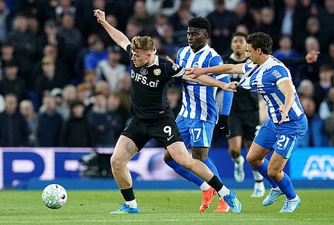 Chelsea's Liam Delap, left, and Brighton and Hove Albion's Olivier Boscagli battle for the ball during the English Premier League soccer match between Brighton & Hove Albion and Chelsea in Brighton, England.