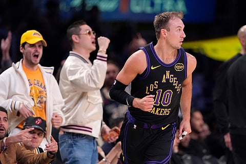 Fans celebrate after Los Angeles Lakers guard Luke Kennard, right, scored during the first half in Game 2 of a first-round NBA playoffs basketball series against the Houston Rockets in Los Angeles.
