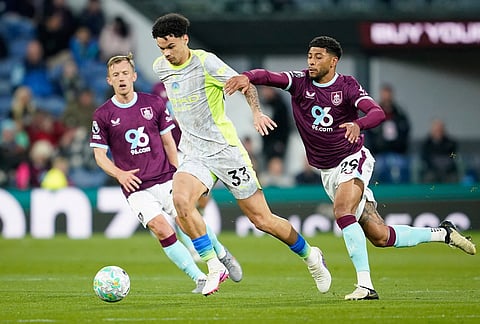 Manchester City's Nico O'Reilly, left, and Burnley's Josh Laurent fight for the ball during the Premier League soccer match between Burnley and Manchester City in Burnley, England.