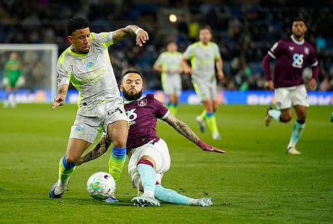 Burnley's Quilindschy Hartman tackles Manchester City's Savinho during the Premier League soccer match between Burnley and Manchester City in Burnley, England.