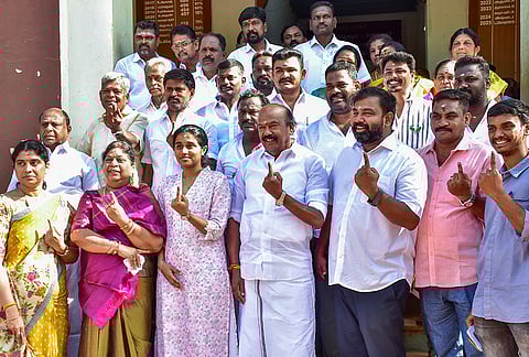 AIADMK candidate from Thiruparankundram constituency, VV Rajan Chellappa, centre front, shows his ink-marked finger after casting a vote in the Tamil Nadu Assembly elections, at a polling station in Madurai.