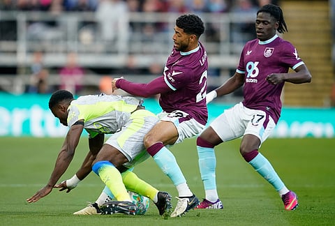 Manchester City's Marc Guehi, left, and Burnley's Josh Laurent fight for the ball during the Premier League soccer match between Burnley and Manchester City in Burnley, England.