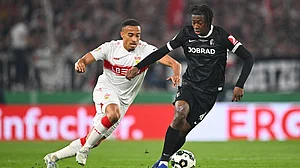 Photo: Tom Weller/dpa via AP : Freiburg's Johan Manzambi, right, turns away Stuttgart's Jamie Leweling during their German Cup semi-final match.