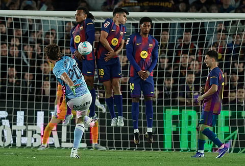 Celta's Marcos Alonso, left, shoots the ball during the Spanish La Liga soccer match between Barcelona and Celta Vigo in Barcelona, Spain.
